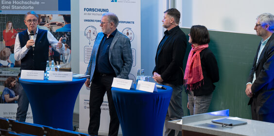 Vier Männer und eine Frau stehen zusammen.