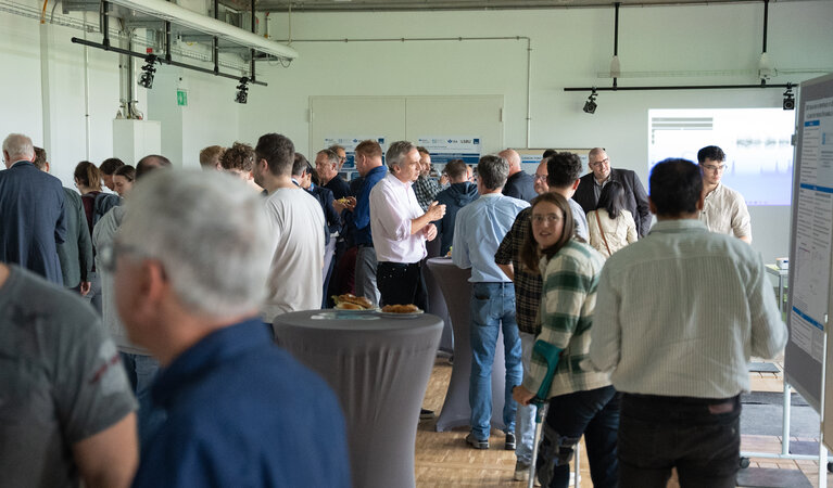 Viele Personen bei einer Pause im Austausch in einem Seminarraum.