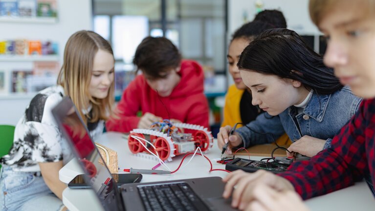 Gruppe von Schülerinnen und Schüler, die technisch arbeiten