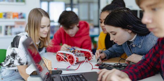 Gruppe von Schülerinnen und Schüler, die technisch arbeiten