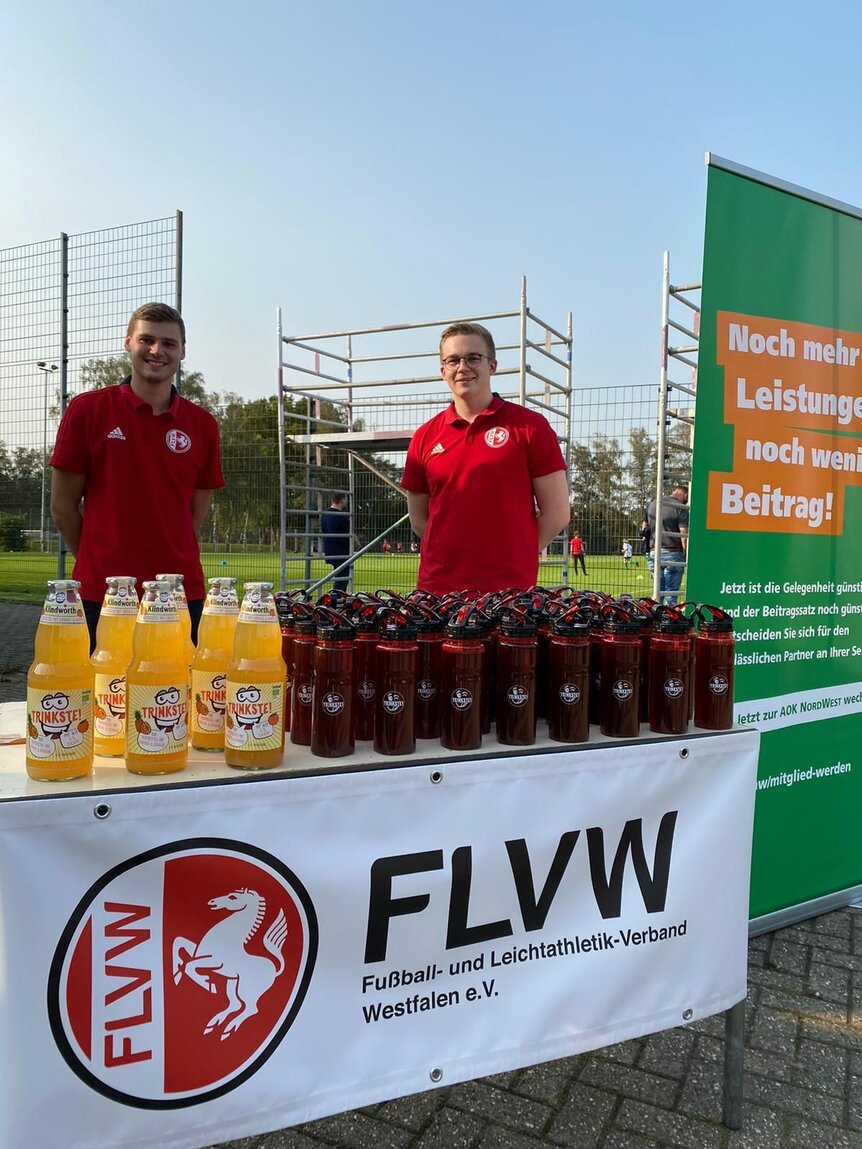 Thorben und Jascha vor einem FLVW Stand mit Getränken