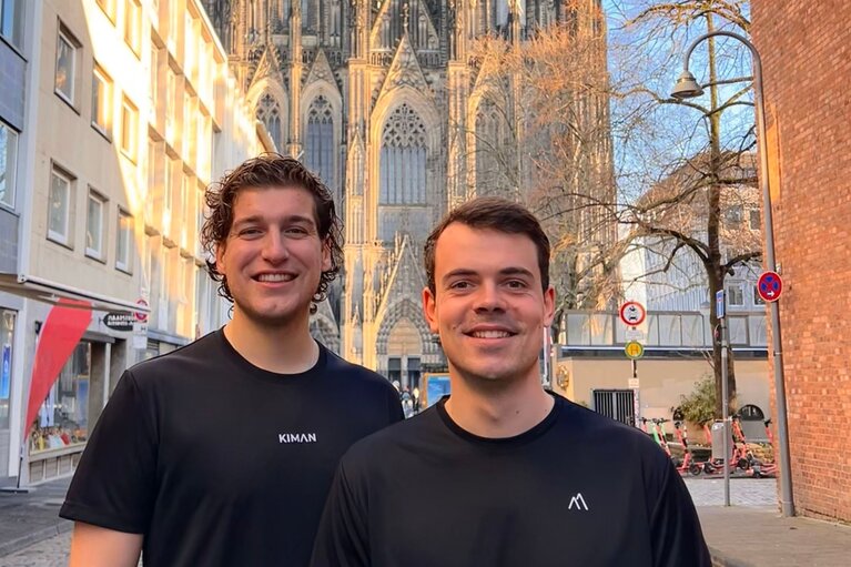 Zwei Männer stehen zusammen vor dem Kölner Dom.