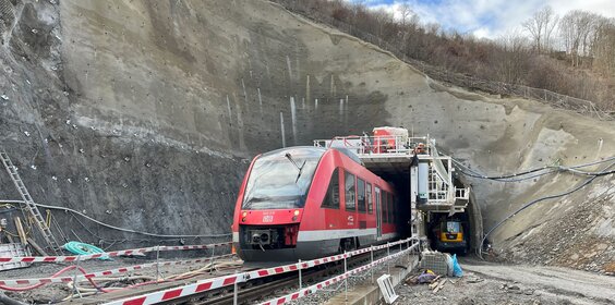 Ein Zug fährt durch einen Tunnel, an dem gearbeitet wird.