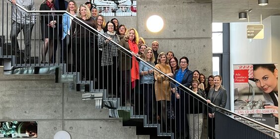 Frauen und Männer auf einer Treppe.